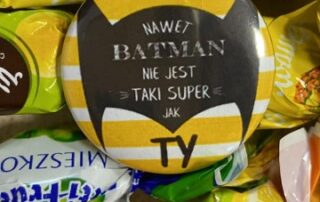 cukierki i przypinka z napisem "nawet batman nie jest taki super jak Ty"