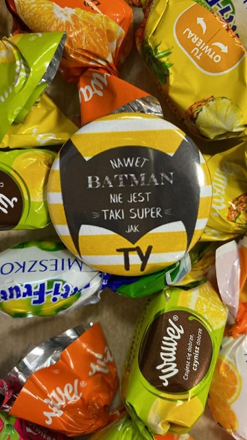 cukierki i przypinka z napisem "nawet batman nie jest taki super jak Ty"