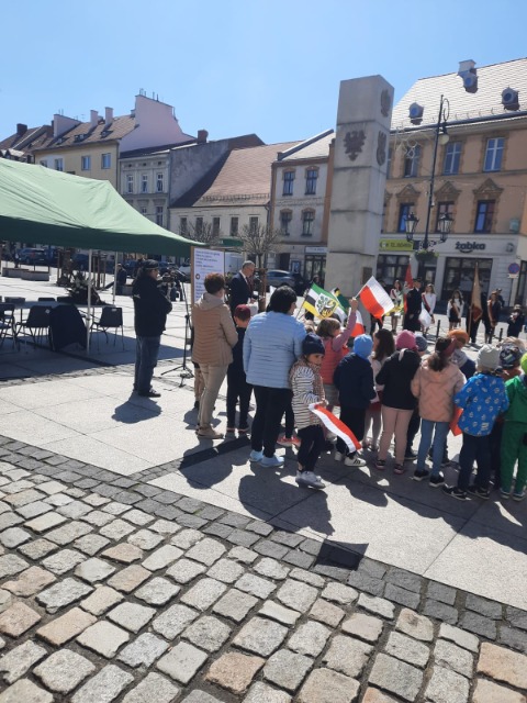 Obchody Dnia Zwycięstwa na średzkim rynku, grupa dzieci z flagami narodowymi