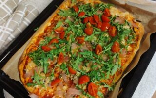 pizza z szynką, pomidorami, pieczarkami i rukolą